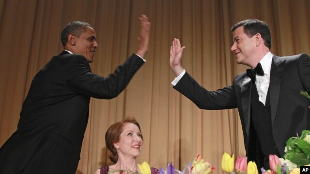 El presidente Barack Obama y el comediante Jimmy Kimmel chocan sus manos, durante la cena anual de los corresponsales ante la Casa Blanca. En medio observa, Careh Bohan, periodista de Reuters.