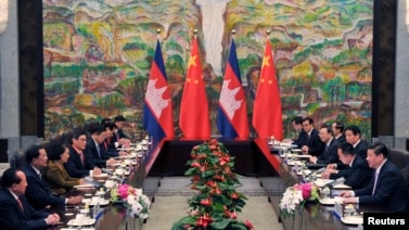Cambodia's Prime Minister Hun Sen (2nd L) and China's President Xi Jinping (R) attend a meeting at Xijiao Hotel in Shanghai May 18, 2014. REUTERS/Kenzaburo Fukuhara