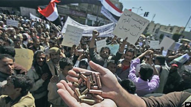 An anti-government protester displays bullet shells, claiming they were fired at demonstrators Tuesday night by Yemeni government supporters, killing at least one demonstrator, while demanding resignation of President Ali Abdullah Saleh, in Sanaa, Yemen, 