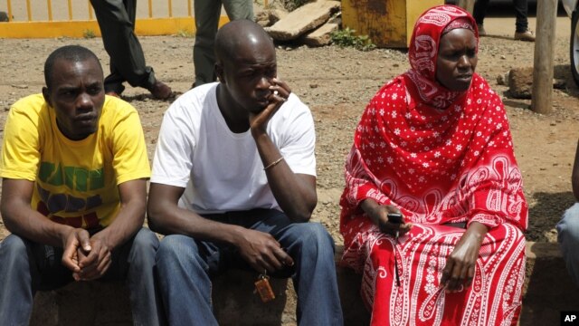 Relatives wait for the bodies of slain police officers to arrive at Wilson Airport in Nairobi, Nov. 13, 2012. Suspected cattle thieves hid on a high hill and ambushed and killed at least 34 police officers pursuing them over the weekend in northwestern Kenya.