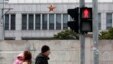 FILE - Locals walk in front of a secretive Chinese military unit, on the outskirts of Shanghai.