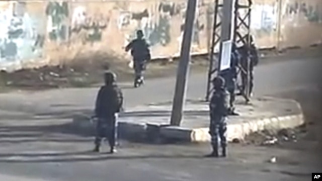 In this image taken from amateur video made available by Sham News Network in Syria  on Dec. 13, 2011, shows pro-government militia on the street in Daraa, Syria.