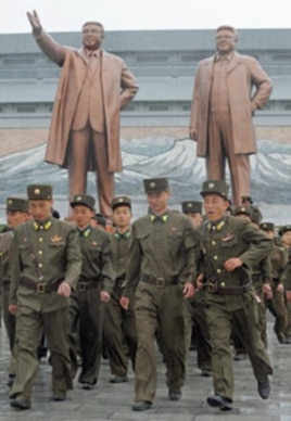 North Korean soldiers walk past bronze statues of North Korea founder Kim Il-sung (L) and late leader Kim Jong-il in Pyongyang, April 25, 2012.