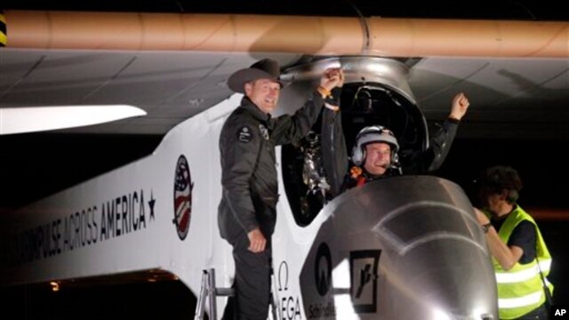Pilot, CEO dan penemu pesawat bertenaga surya "Solar Impulse", Andre Borschberg (kiri) menyambut pilot Bertrand Piccard di Bandara Internasional Sky Harbor di Phoenix, Sabtu dini hari (4/5) pasca penerbangan perdana lintas Amerika. Pesawat tersebut menempuh penerbangan selama 20 jam dari California utara.