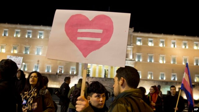 Gay rights supporters gather outside Greece's Parliament to voice approval of a civil partnership bill being debated by lawmakers, in central Athens, Dec. 22, 2015.