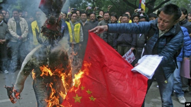 Tibetan exiles burn a Chinese flag and an effigy representing a Chinese official during a protest in New Delhi, January 17, 2012.