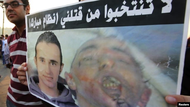Demonstrators carry poster of Khaled Said on the second anniversary of his death by Egyptian police, Cairo, June 6, 2012.