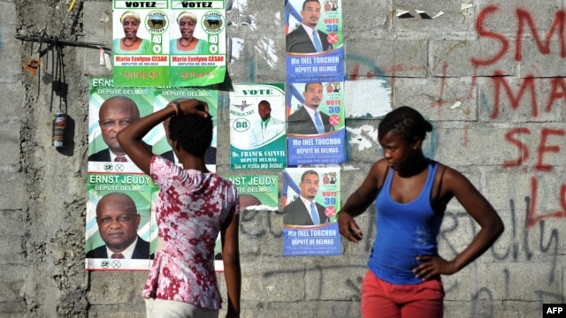 A wall is plastered with campaign posters of political candidates in the commune of Delmas, Port-au-Prince, on Aug. 5, 2015.