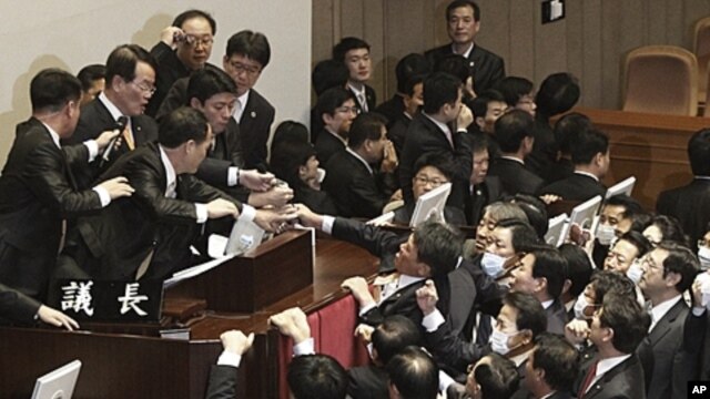 National Assembly Vice Speaker Chung Eui-hwa, second from left top, wearing glasses, declares the passage of a bill on ratification of a South Korea-U.S. free trade agreement as opposition lawmakers try to stop it at the National Assembly in Seoul, South 