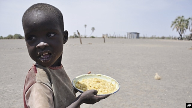 A young boy walks away with his food from a government-sponsored feeding center in central Turkana, Kenya, August 30, 2011