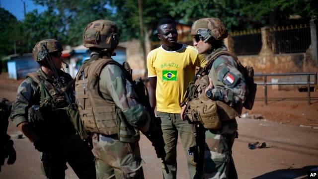 FILE - French Sangaris peacekeepers are seen speaking to a local resident outside Fatima Church in Bangui, Central African Republic.