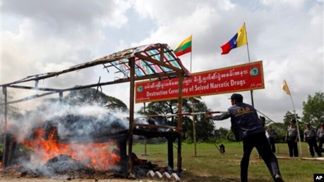 Seorang polisi Myanmar menyulutkan api ke tumpukan narkoba yang berhasil disita dan dimusnahkan pada acara Anti Penyelundupan Obat-obatan Sedunia, 26/6/2013. 
