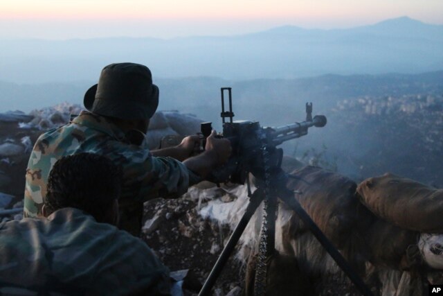 FILE - Syrian army personnel, backed by Russian airstrikes, fires machine gun in Latakia province, near border with Turkey, Oct. 10, 2015.