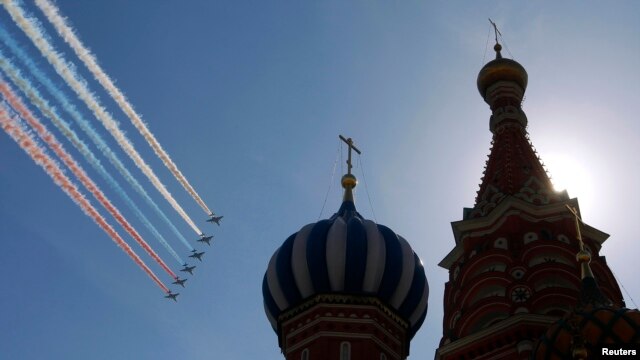 Купола Собора Василия Блаженного в Москве на фоне российского триколора