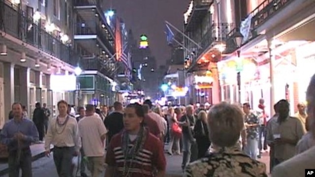 Tourists and locals walk down Bourbon Street in New Orleans