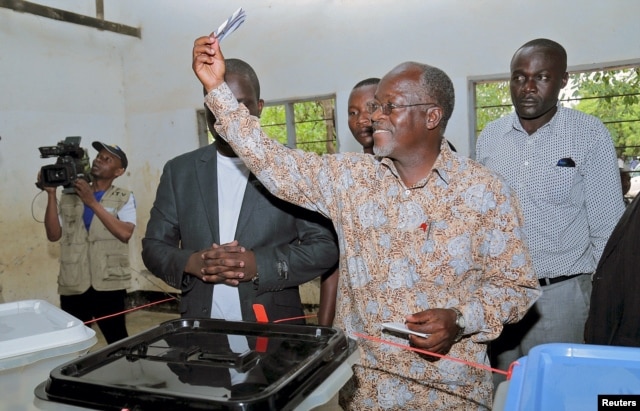 Tanzanian presidential candidate of the ruling CCM party, John Magufuli, displays his ballot paper before casting his vote in the presidential and parliamentary election at his hometown Chato district, in Geita region, Tanzania, Oct. 25, 2015.