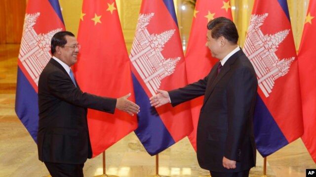 Cambodian Prime Minister Hun Sen (L) shakes hands with China's President Xi Jinping before a meeting at the Great Hall of the People in Beijing, Nov. 7, 2014.