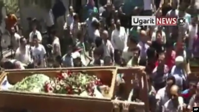 Mourners carry the body of a person during a funeral ceremony in the city of Homs, Syria in this image made from amateur video released by Ugarit News, Aug. 2, 2011