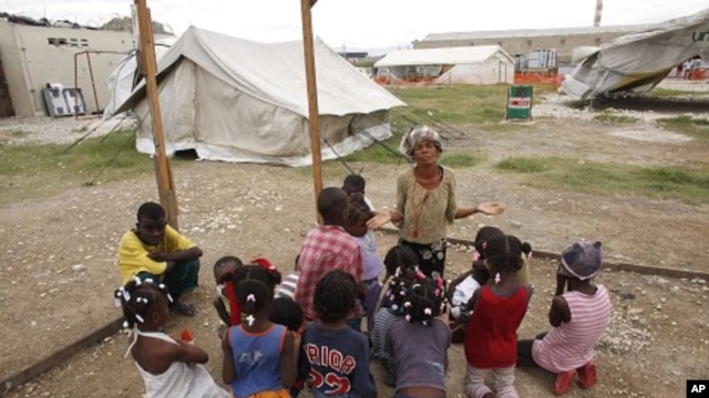 An earthquake survivor prays with children in Port-au-Prince, Haiti (Nov 2010 file photo)