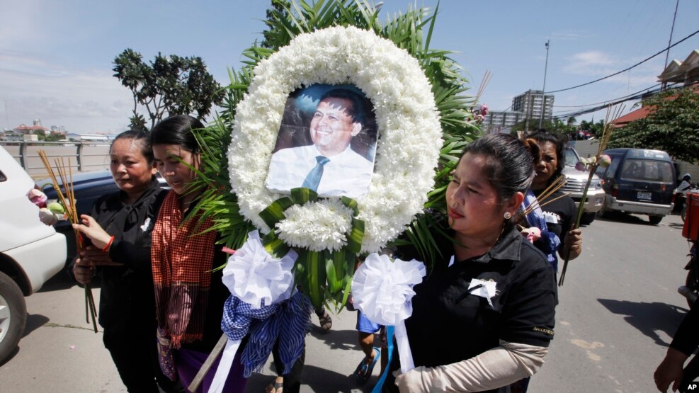 Cambodian community activists carry a wreath during the funeral procession of government critic Kem Ley in Phnom Penh, July 11, 2016. 