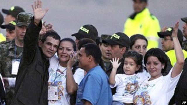 Carlos Jose Duarte, a Colombian policeman recently freed by FARC rebels, waves at the media with his relatives as he arrives at Villavicencio's airport April 2, 2012. 