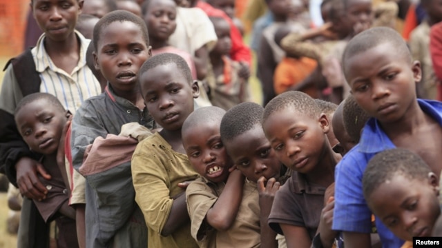 Refugee children, displaced by continued fighting in north Kivu province in the Democratic Republic of Congo (DRC), wait for food in the Nyakabande refugee transit camp in Kisoro town, 521 km (324 miles) southwest of Uganda's capital Kampala, July 13, 201