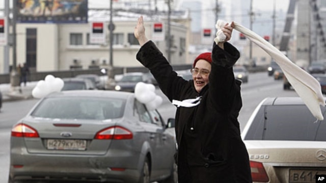 A woman greets participants of a car rally calling for a free presidential election, Moscow, February 19, 2012.