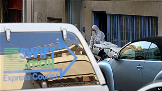A Greek anti-terrorist police officer investigates a private delivery company after an explosion in Athens, 1 Nov 2010