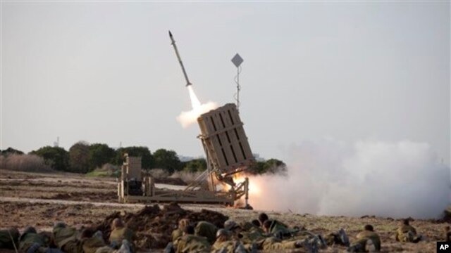 Binh sĩ Israel nằm trên mặt đất bên cạnh hệ thống tên lửa đánh chặn "Vòm Sắt" tại thành phố Ashdod, Israel.