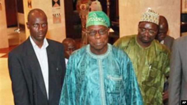 Former Nigerian President Olusegun Obasanjo, center, leaves his hotel for a meeting with incumbent Ivorian President Laurent Gbagbo in Abidjan, Ivory Coast.