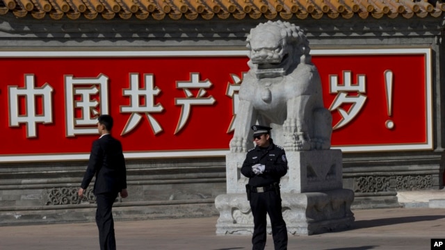 警察和便衣守在共产党万岁的巨幅标语墙前。(2013年11月7日)    