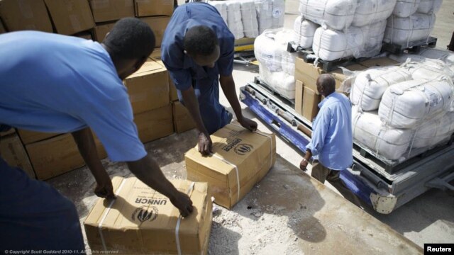 Workers unload emergency aid from a UNHCR-chartered aircraft in Mogadishu, August 8, 2011. 