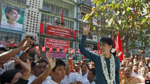 Burma's pro-democracy leader Aung San Suu Kyi waves at supporters during the opening ceremony of the National League for Democracy party's Mingalar Taung Nyunt township office in Rangoon, January 17, 2012.