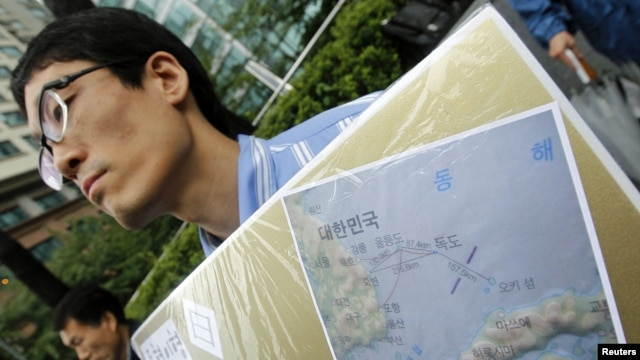 A South Korean activist holds a map of Dokdo islets during a rally denouncing Japan's sovereignty claim on the islets, in front of the Japanese Embassy in Seoul,  September 10, 2010.