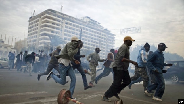 Anti-government protestors run from tear gas in Senegal's capital Dakar, February 15, 2012.