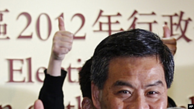 The next Hong Kong Chief Executive Leung Chun-ying celebrates as he attend a news conference at a vote counting station in Hong Kong, March 25, 2012. 