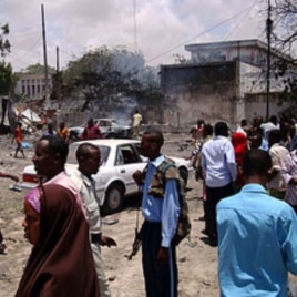 People mill around the scene where a suicide attack took place in Somalia's capital Mogadishu, October 4, 2011.