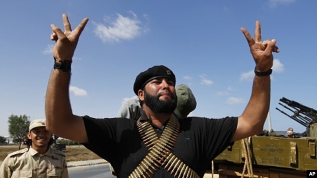 A member of the forces loyal to Libya's interim rulers flashes the victory sign as he prepares for an assault on Muammar Gaddafi's hometown Sirte September 24, 2011.