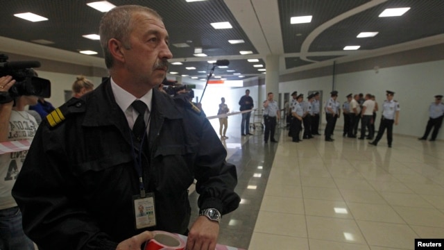 Russian airport security staff secure an area after former U.S. spy agency contractor Edward Snowden was granted documents that will allow him to leave the transit area of Sheremetyevo airport in Moscow, July 24, 2013. 