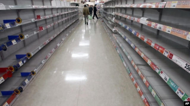 People shop for food from almost empty shelves at a big-box supermarket in Tokyo. Supermarket shelves are running empty despite authorities assuring citizens there is no need to panic from the crisis unfolding at a quake-stricken nuclear power plant, Marc