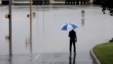 A man surveys floodwaters caused by heavy rains, May 25, 2013, in San Antonio.