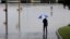 A man surveys floodwaters caused by heavy rains, May 25, 2013, in San Antonio.