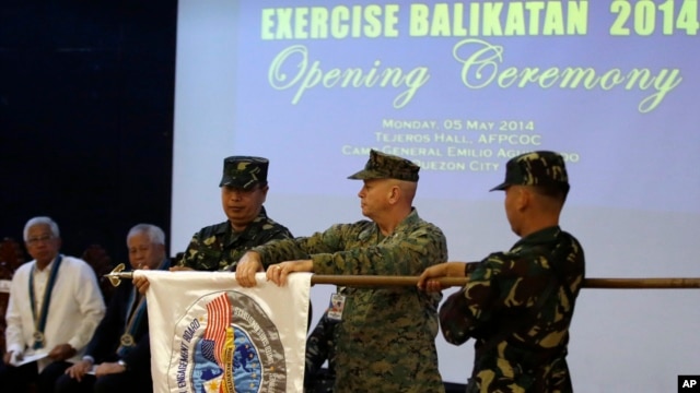 U.S. Marine Col. John Rutherford, 2nd from R, and Philippine Army Maj.Gen. Emeraldo Magnaye, 3rd from R, unfurl the joint U.S.-Philippines military exercise flag at Armed Forces of the Philippines headquarters in Manila, Philippines, on May 5, 2014.