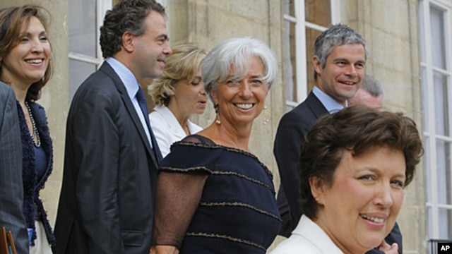 French Finance Minister Christine Lagarde, center, stands with ministers as she leaves the Elysee Palace in Paris, after the weekly Cabinet meeting, June 29, 2011