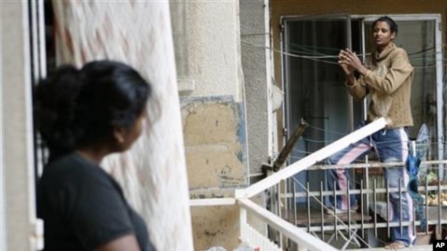 An Ethiopian maid, right, chats with another maid from Sri Lanka, left, as they stand on balconies in Beirut (File Photo)