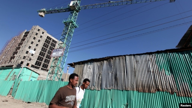 People walk past office blocks under construction in Ethiopia's capital Addis Ababa, January 27, 2010.