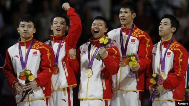 Feng Zhe (L-R) of China and teammates Guo Weiyang, Chen Yibing, Zhang Chenglong and Zou Kai celebrate with their gold medals after taking first place in the men's gymnastics team final in the North Greenwich Arena at the London 2012 Olympic Games, July 30