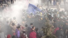 In this handout photo released by The International Campaign for Tibet (ICT) on December 7, 2012, paramilitary policemen are seen closing in on Dorje Rinchen's body after his self-immolation, in Xiahe,  Gansu province, October 23, 2012. 