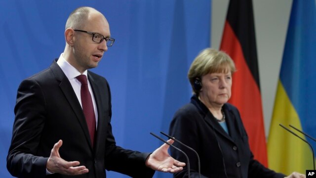 Thủ tướng Đức Angela Merkel (phải) và Thủ tướng Ukraine Arseniy Yatsenyuk nói chuyện trong cuộc họp báo tại dinh Thủ tướng ở Berlin, Đức, 8/1/15