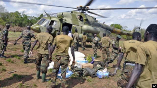 Ugandan soldiers, who are tracking down Lord's Resistance Army (LRA) fugitive leaders, load supplies from a military helicopter in a forest bordering Central African Republic, South Sudan and Democratic Republic of Congo, near river Chinko, April 18, 2012.